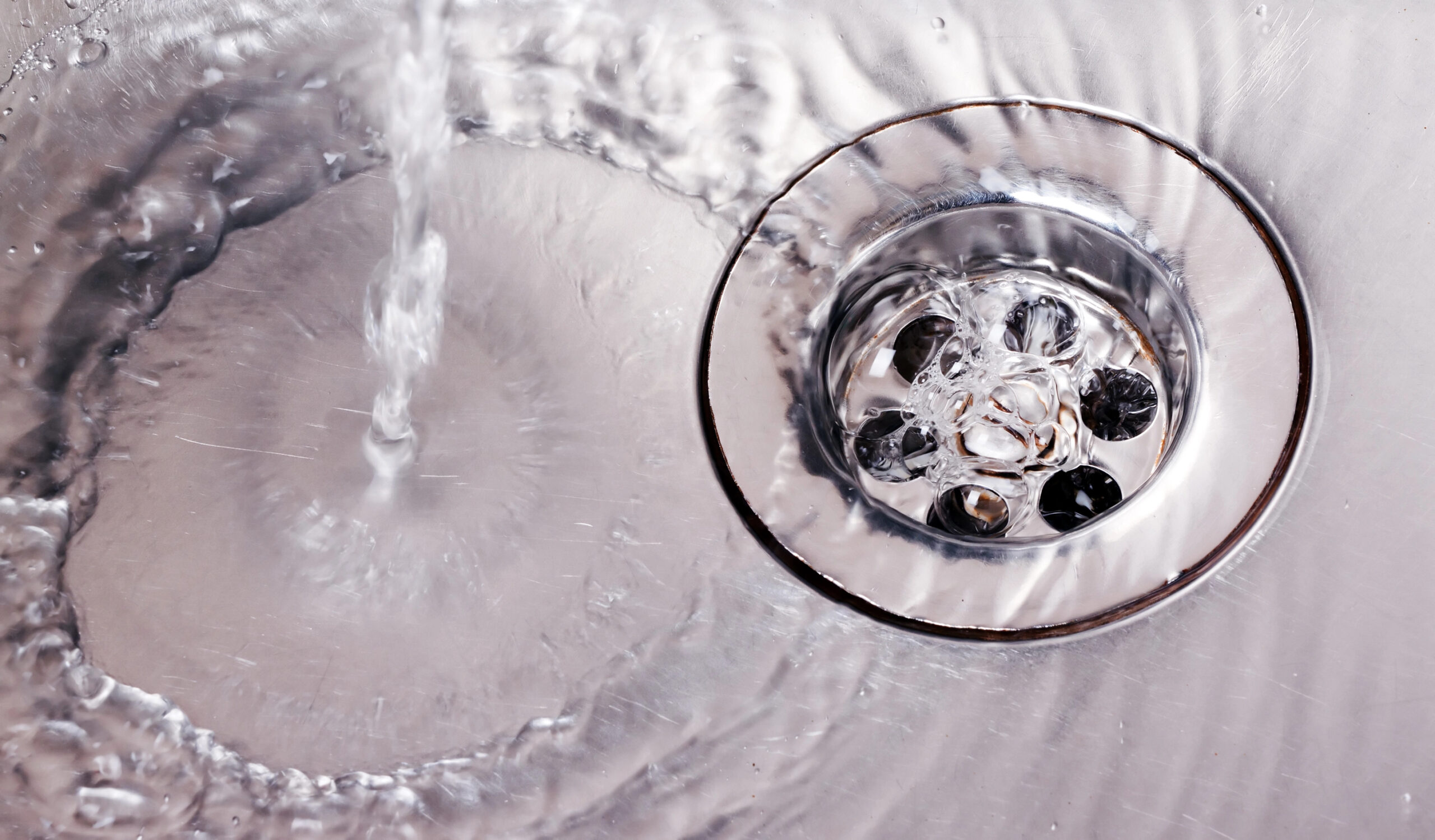 Efficient water flow in a maintained drain in Regina, demonstrating clear drainage.