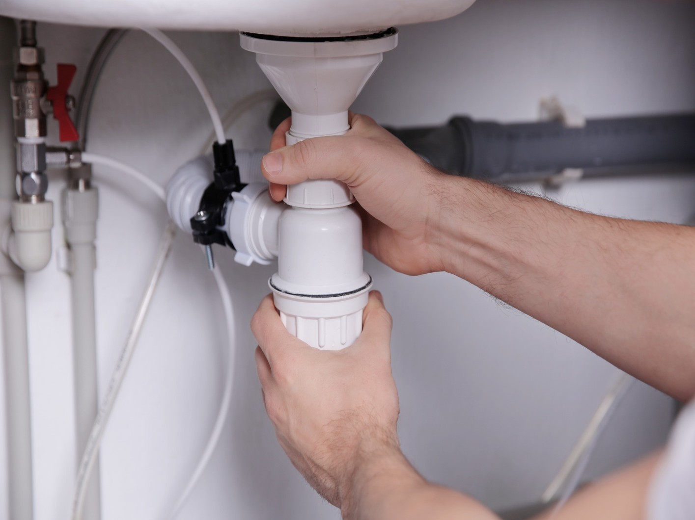 Plumber installs a P-trap, a crucial component for modern and effective home drainage systems.